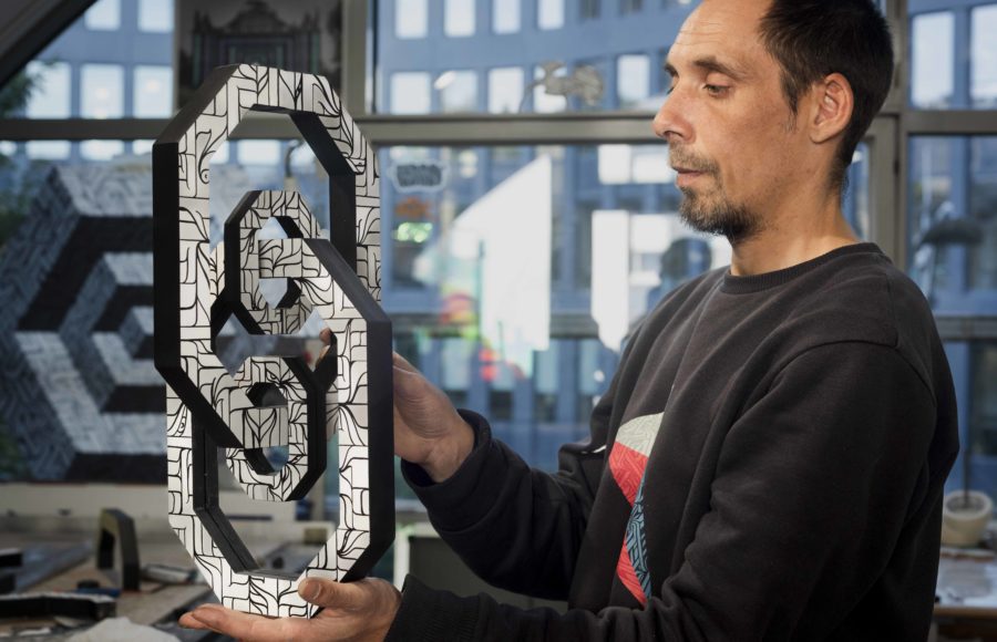 l'arstiste ASTRO dans son atelier avec une de ses sculptures