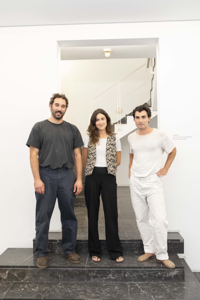 Portrait of artists Javi Cruz, Laura Palau, and Andrés Izquierdo at Luis Adelantado gallery during the exhibition Llaga de mar, alivio de monte, presented at Abierto Valencia 2025.