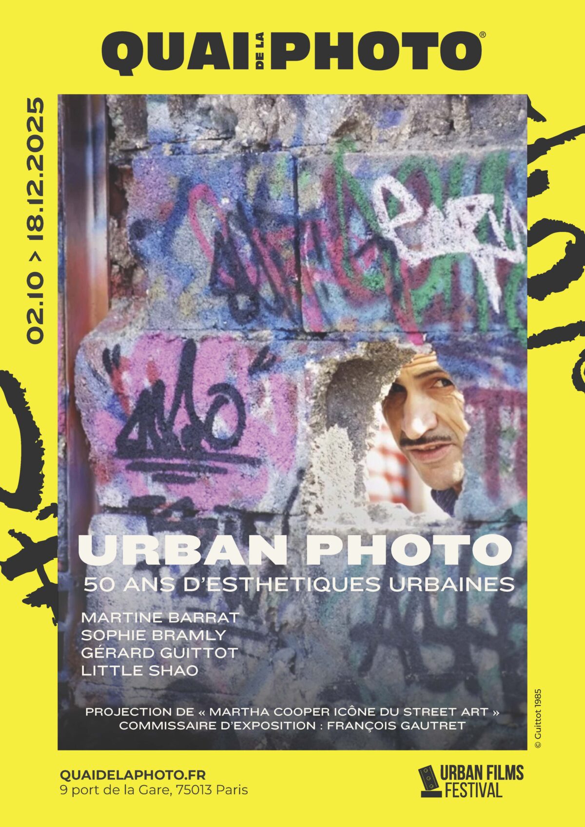 Affiche « Urban Photo – 50 ans d’esthétiques urbaines » (02.10–18.12.2025), Quai de la Photo, Paris ; visuel d’un homme vu à travers un mur graffé (© Guittot, 1985).