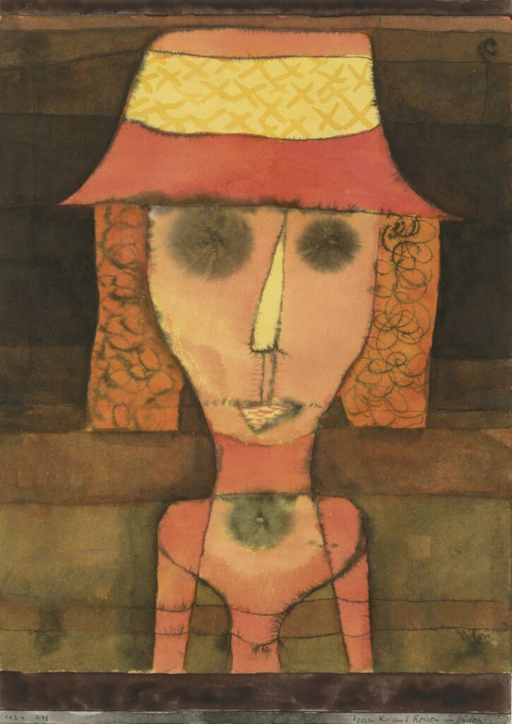 igure féminine stylisée au visage rose, chapeau jaune et rouge, grands yeux noirs, dans un décor aux tonalités chaudes — aquarelle de Paul Klee 1924
