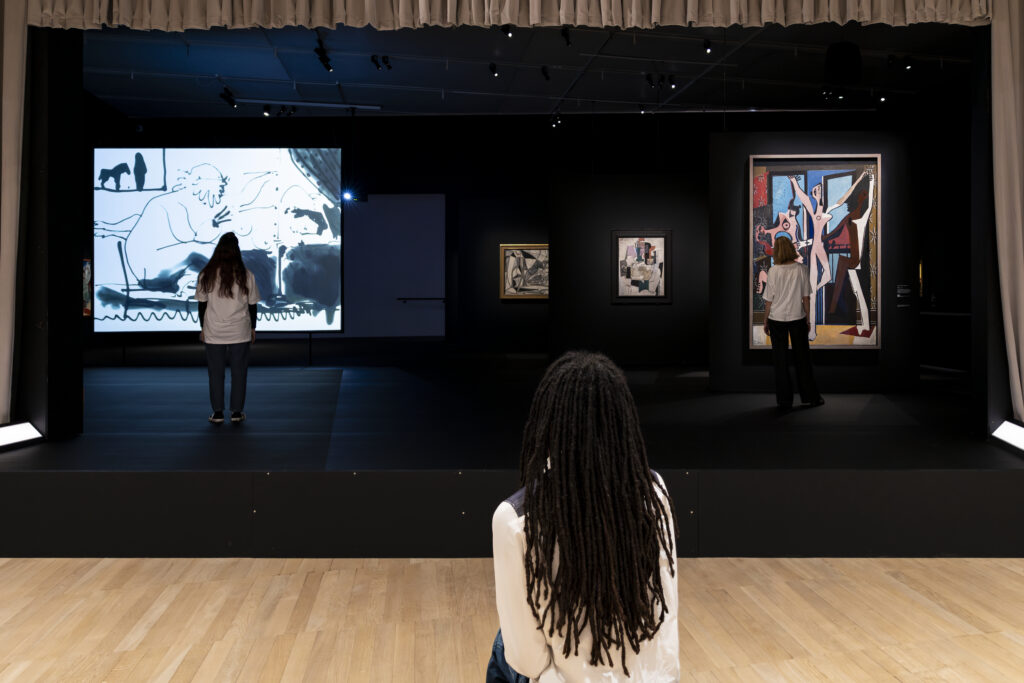 Salle immersive de l’exposition Théâtre Picasso à la Tate Modern, avec projections vidéo et Les Trois Danseuses (1925) de Picasso.