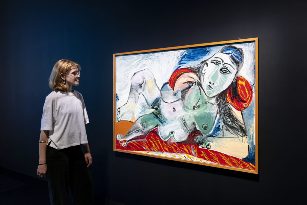 Visitor looking at a Pablo Picasso painting of a reclining woman, during the Theatre Picasso exhibition at Tate Modern, London 2025.