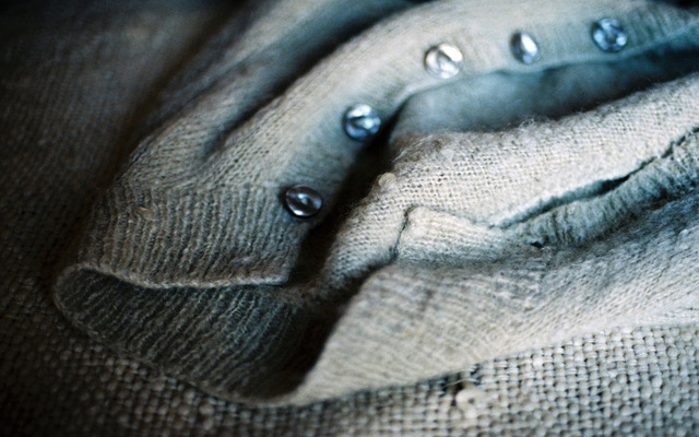 Gros plan sur un tricot de laine et ses boutons — textures textiles, photographie d’intérieur, Cendrine Genin, série “Les Intimes”.