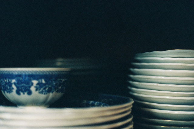 Bol et assiettes en porcelaine bleue et blanche empilés dans un buffet — nature morte photographique, Cendrine Genin, Hyères.