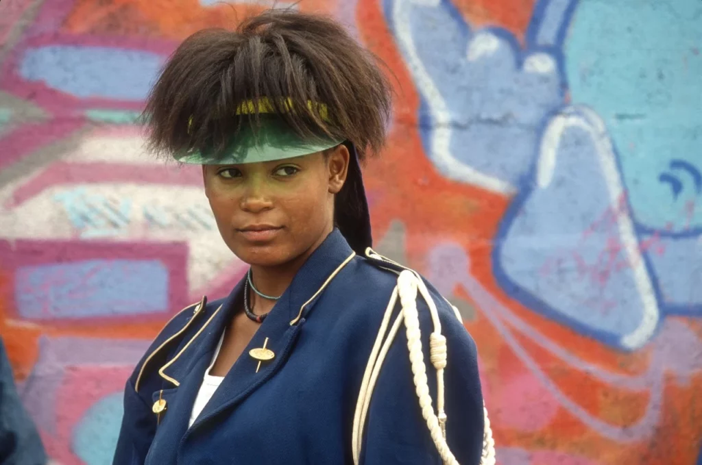 Portrait d’une jeune femme devant un mur graffé, Paris années 1980 — culture hip-hop, photographie de Gérard Guittot, Urban Photo 2025