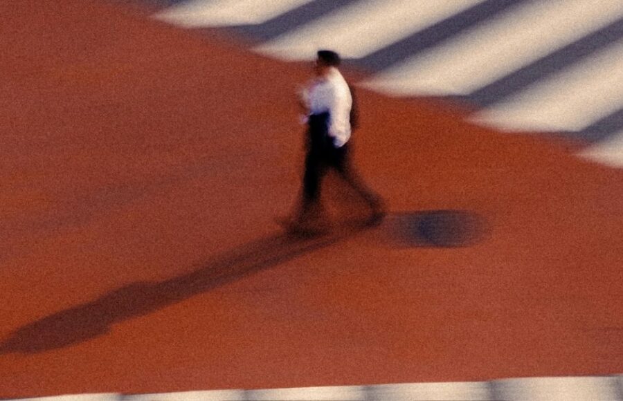 Piéton flou traversant un carrefour rouge avec zébrures blanches, effet de filé à Séoul. Art mag