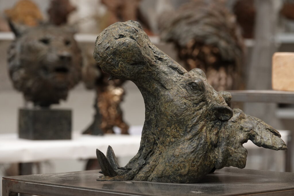 Bronze sculpture by Pierre-Jean Chabert depicting an animal head blending hippopotamus features with mythic forms. The artist captures the raw energy of the material in a powerful, expressive composition.