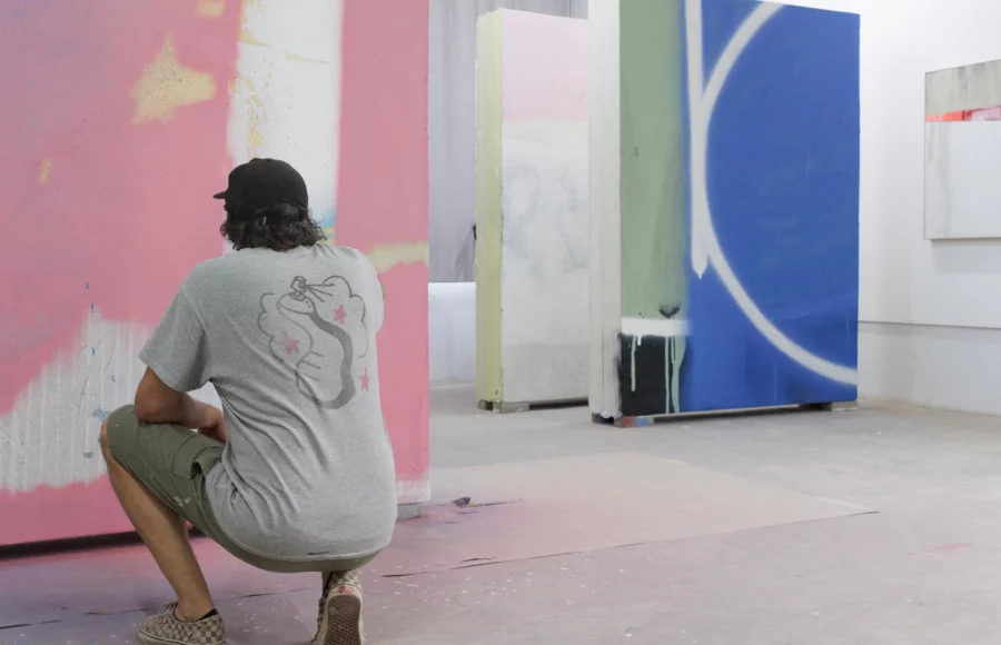 L’artiste Tilt en résidence à Jardin Rouge, Marrakech (2025), peignant un grand panneau abstrait rose, bleu et noir pour l’exposition Waiting for Barbarians à la Fondation Montresso*. magazine art mag