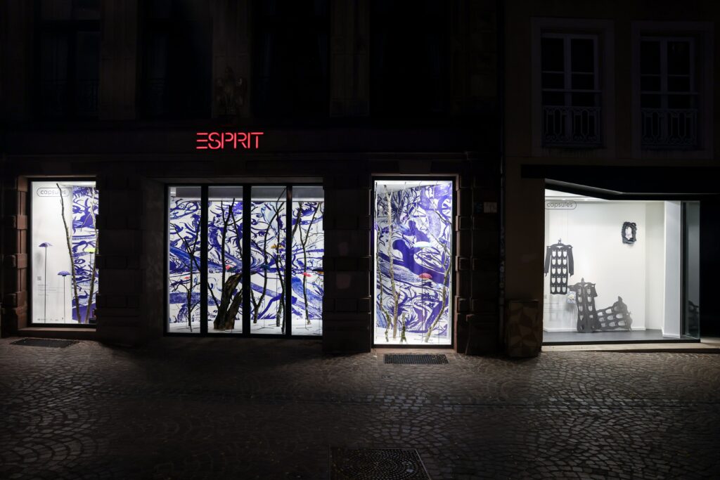 Vitrines Capsules de Luxembourg Art Week 2025, présentant l’installation nocturne aux motifs bleus et blancs d’Anna Bochkova, « Soft Futures », combinée à des sculptures noires exposées en façade — une intervention artistique en ville capturée de nuit. magazine art mag