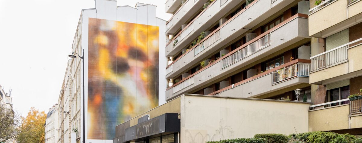 « Fresque monumentale floue et colorée de Léa Belooussovitch sur la façade d’un immeuble du 11ᵉ arrondissement de Paris, réalisée en hommage aux victimes du 13-Novembre.