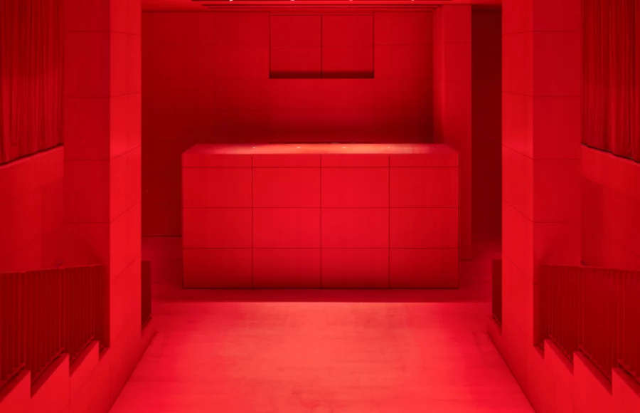 Intérieur du Studio Marie-Claude Beaud au Palais-Royal, auditorium de 110 places du nouveau bâtiment de la Fondation Cartier conçu par Jean Nouvel, baigné d’une lumière rouge immersive et dédié aux arts vivants, projections et rencontres.