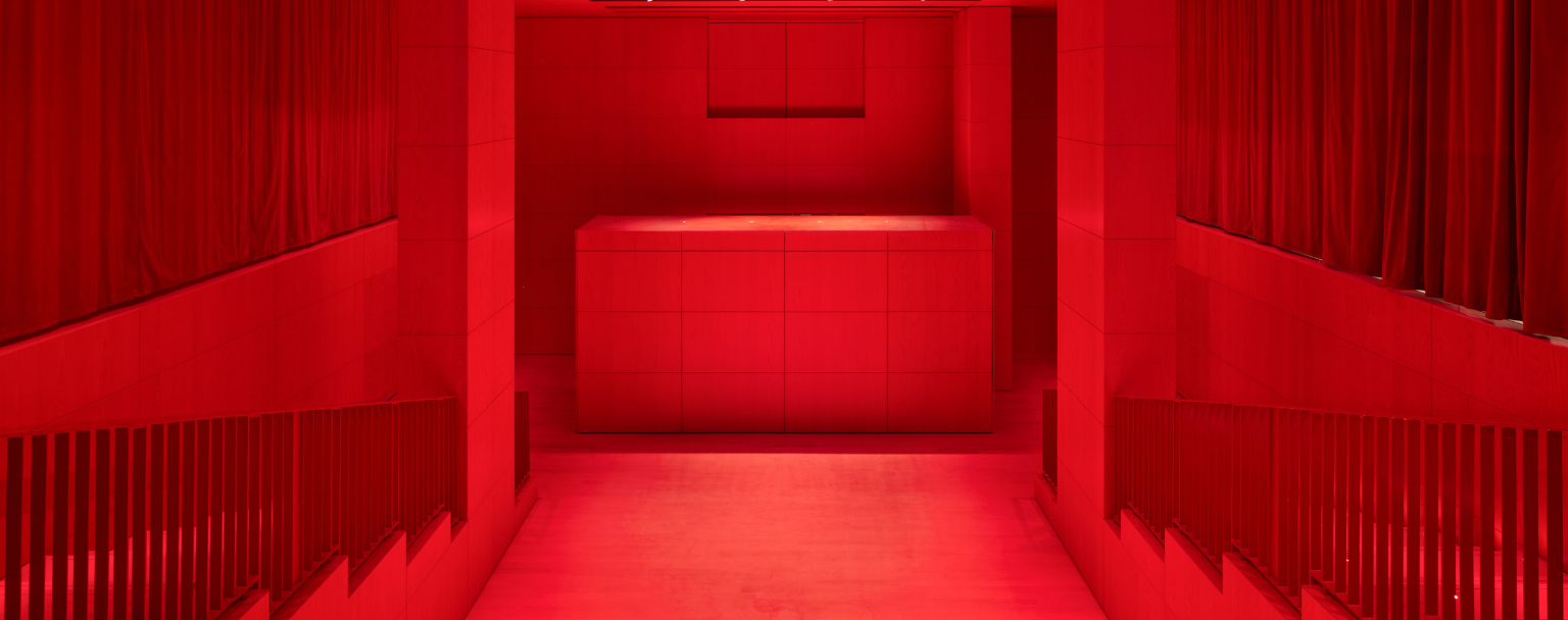 Intérieur du Studio Marie-Claude Beaud au Palais-Royal, auditorium de 110 places du nouveau bâtiment de la Fondation Cartier conçu par Jean Nouvel, baigné d’une lumière rouge immersive et dédié aux arts vivants, projections et rencontres.