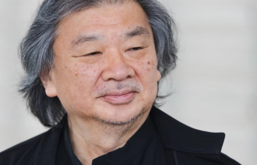 Portrait of Shigeru Ban, Japanese architect and Pritzker Prize laureate, photographed in three-quarter view, wearing black, against a light background.