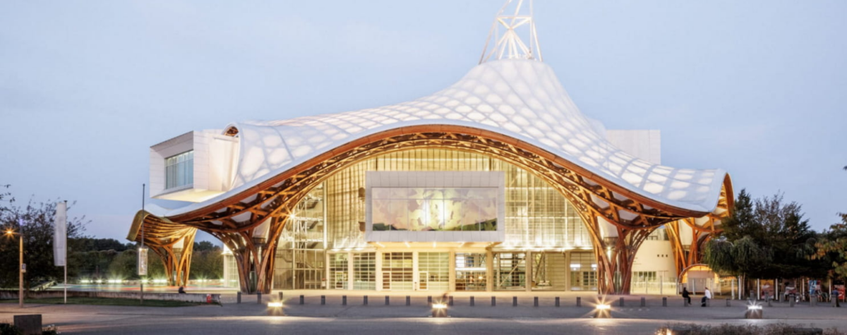Façade du Centre Pompidou-Metz, bâtiment conçu par Shigeru Ban, reconnaissable à sa toiture ondulante en bois et membrane blanche, photographié à la tombée du jour.