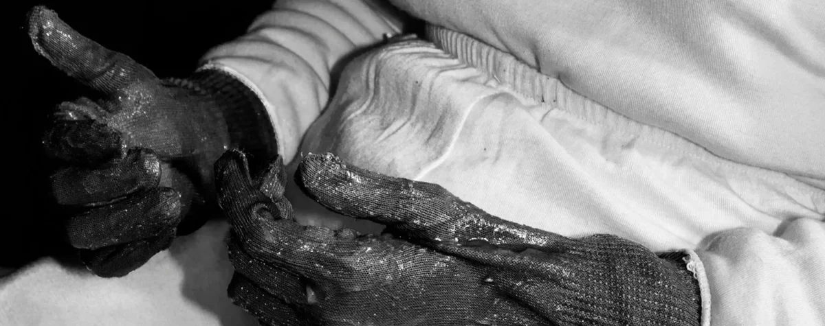 Photographie de Marie Quéau issue de l’exposition FURY au BAL : gros plan en noir et blanc sur des mains gantées marquées par l’effort, illustrant les états-limites du corps et la violence contrôlée documentée par la photographe.