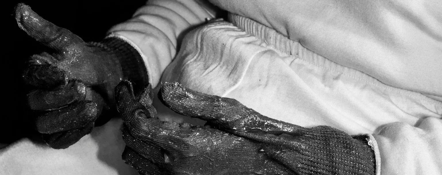 Photographie de Marie Quéau issue de l’exposition FURY au BAL : gros plan en noir et blanc sur des mains gantées marquées par l’effort, illustrant les états-limites du corps et la violence contrôlée documentée par la photographe.