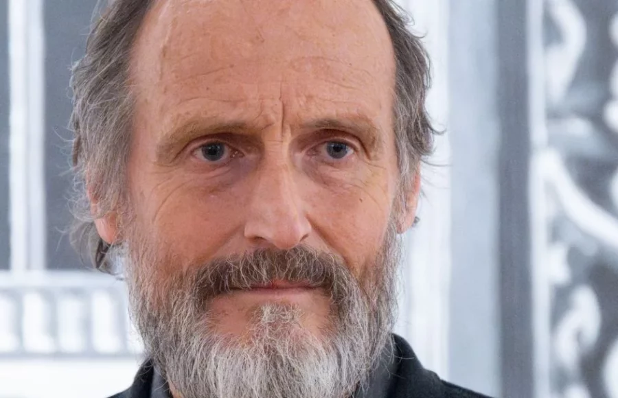 Portrait d’un homme barbu à l’expression neutre, photographié en intérieur devant un décor graphique en noir et blanc, dans le cadre d’un événement lié à l’art contemporain et à la céramique. Art mag