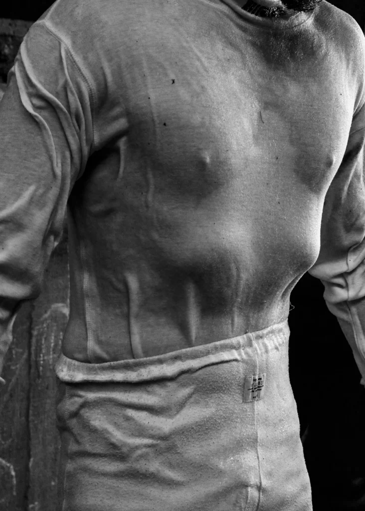 Torse contracté d’un cascadeur en combinaison de protection, capturé par Marie Quéau dans la série FURY, illustrant l’effort physique intense et la performance contrôlée lors des entraînements de cascades. publié par Art Mag