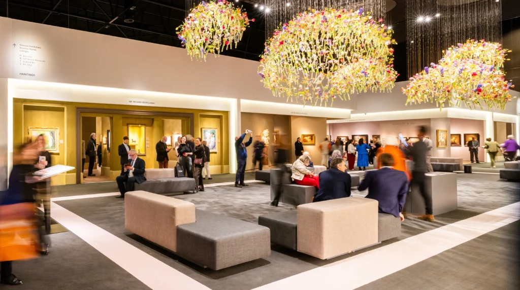 Central lounge area at TEFAF Maastricht 2026, with visitors moving between art galleries, floral installations, and exhibited works. Magazine ART MAG