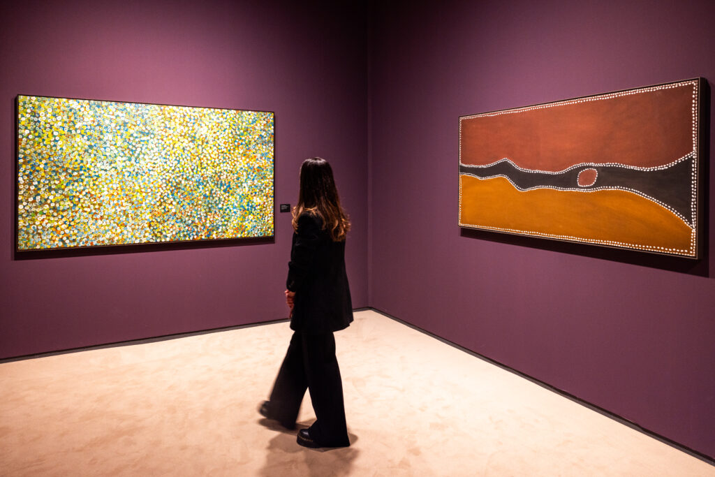 Visitor viewing two contemporary abstract paintings in a gallery at TEFAF Maastricht 2026, featuring modern and Aboriginal art. published by Art Mag