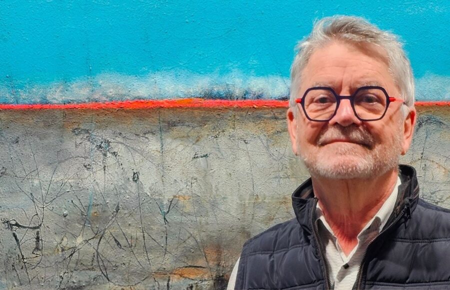 portrait de jean claude bertrand devant une de ces toiles