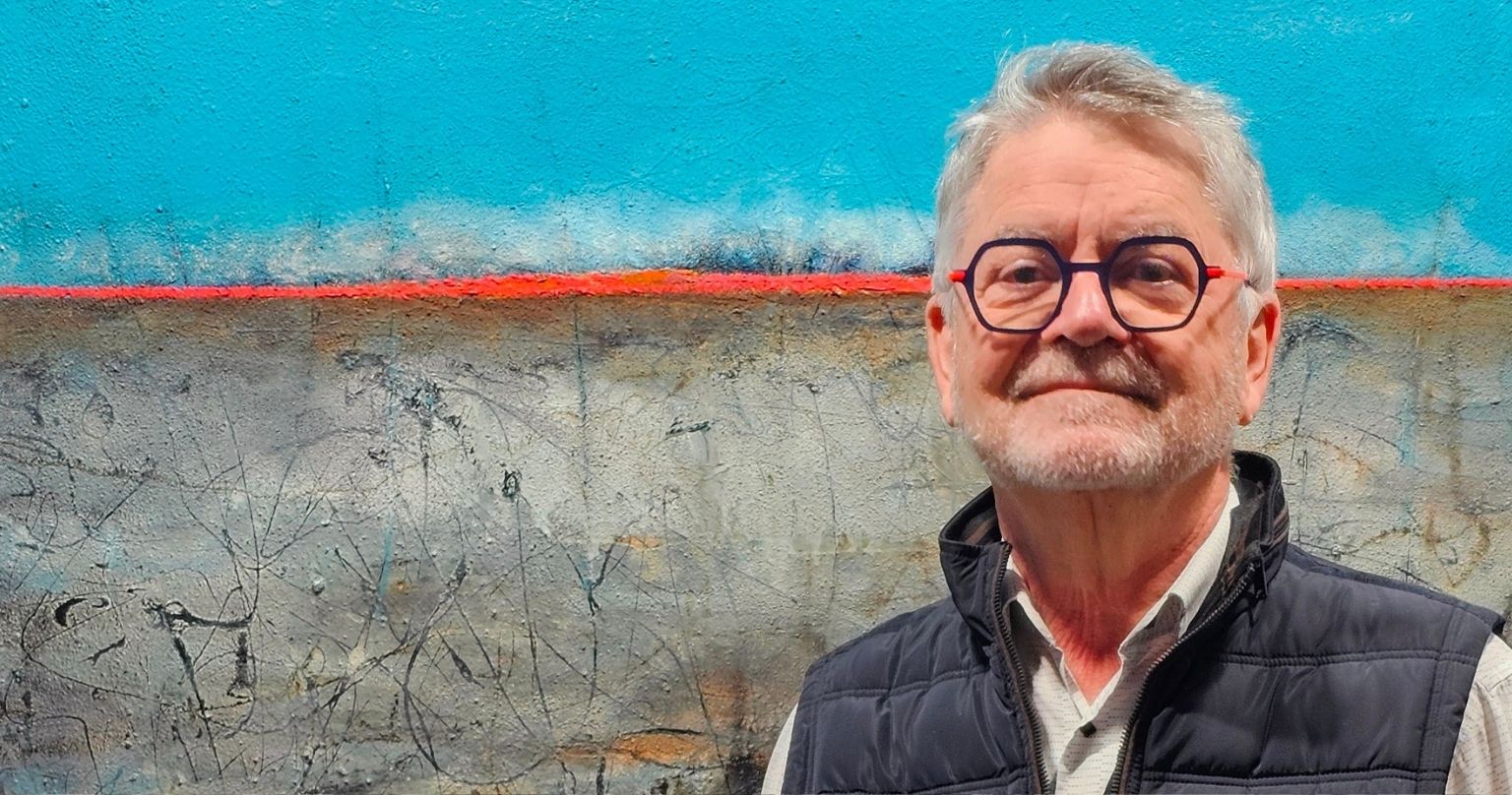 portrait de jean claude bertrand devant une de ces toiles