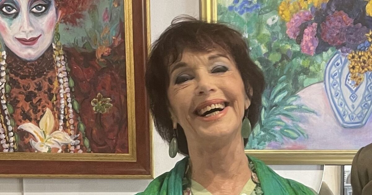 Anny Duperey peintre devant ses tableaux lors d'une exposition, une œuvre où la couleur et la lumière occupent une place centrale.