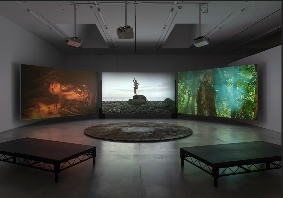 Vue de l’installation vidéo immersive Creation Paradigm de Joshua Serafin, composée de trois écrans montrant des performances entre paysages naturels et univers sonore.